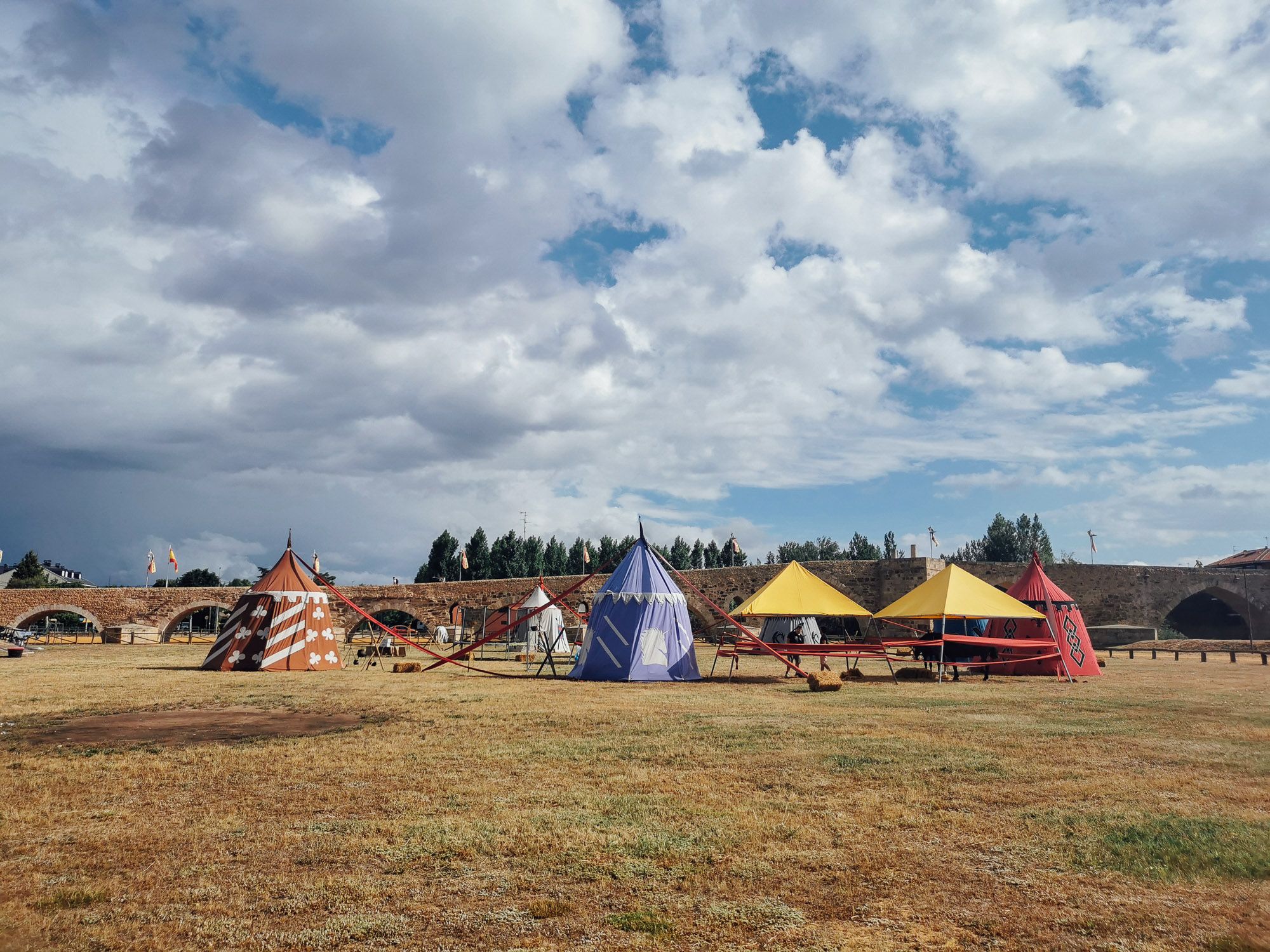 บริเวณลานใต้สะพาน มีการตั้งเต๊นท์สีสด ลวดลาย code of arm เตรียมการแข่งขัน Jousting