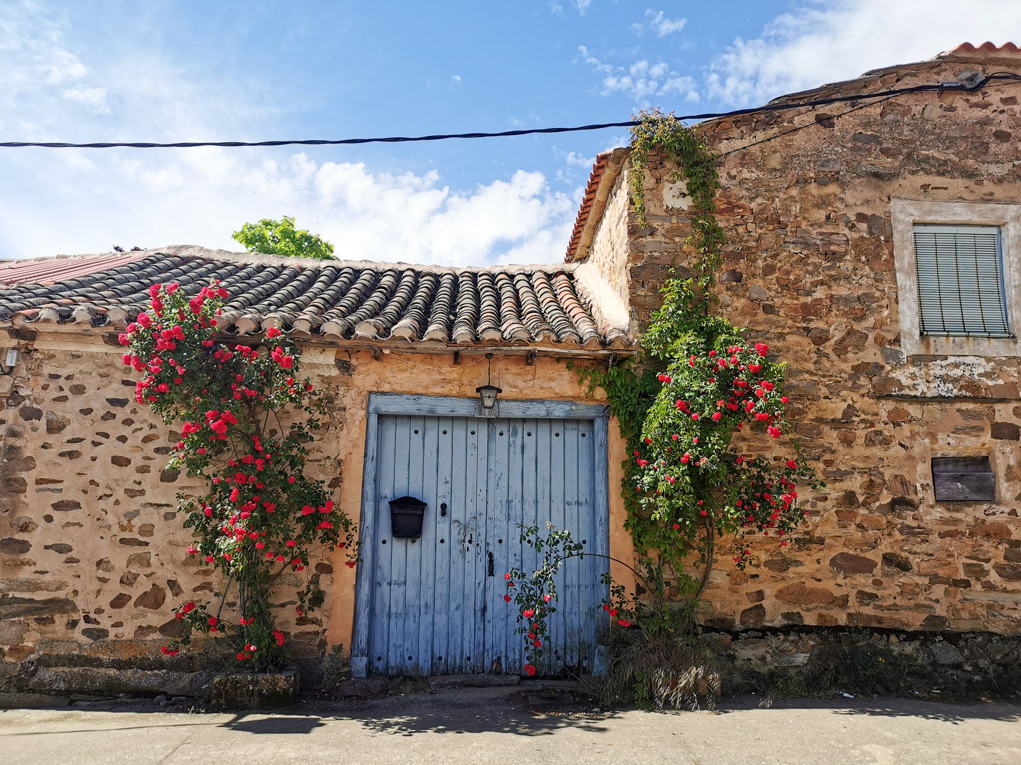 หมู่บ้านแบบ Maragato Village ก่อด้วยหินแบบโบราณ ประตูบ้านสีฟ้าสด พร้อมปลูกดอกกุหลาบสีแดงสดไม่แพ้กัน
