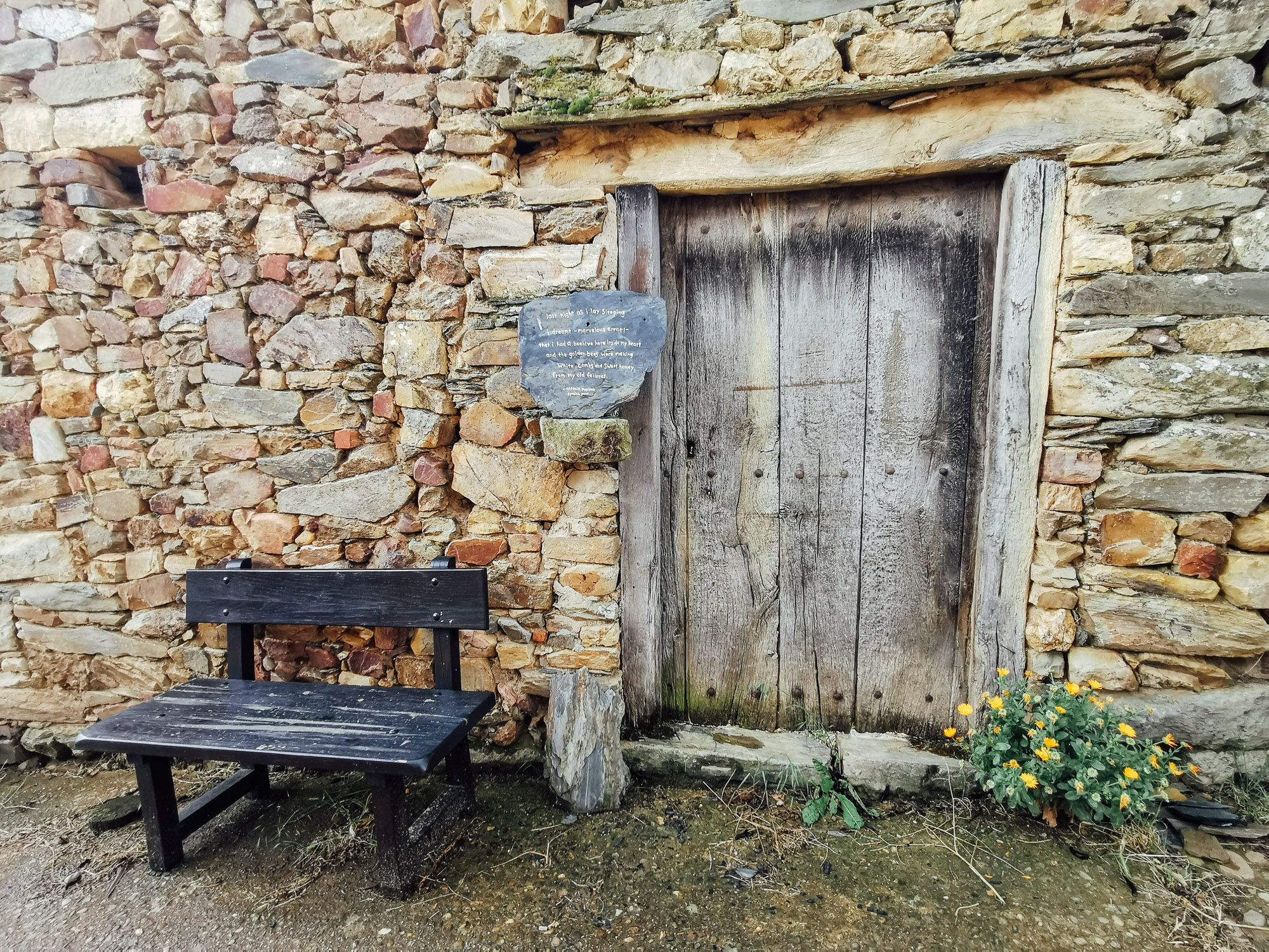 บ้านก่อด้วยหินแบบ Maragato Villages ด้านหน้ามีเก้าอี้ไม้ตั้งอยู่